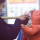 A staff member checks the body temperature of a child after a train from Wuhan arrived at Hangzhou Railway Station in Hangzhou, China.